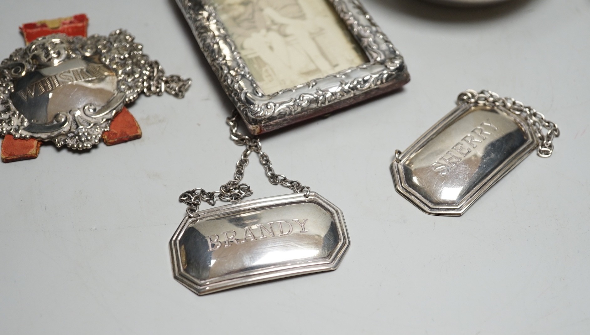 A George V silver octagonal baluster sugar caster, by Walker & Hall, 16.4cm, a modern silver taste du vin, three modern silver wine labels, a silver shell salt, silver condiment spoon and a late Victorian miniature silve